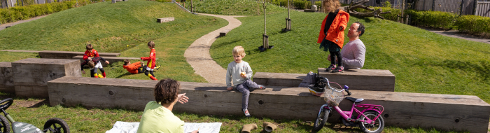 ouders en kinderen op een grasveldje in een nieuwbouwwijk