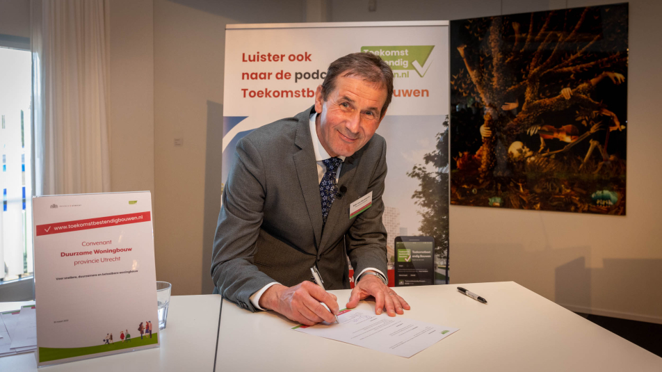 gedeputeerde Rob van Muilekom tekent het convenant duurzame woningbouw